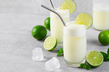 Brazilian Lemonade, Refreshing Creamy Lemonade or Limeade with Lime Slices and Mint on Grey Background - obrazy, fototapety, plakaty