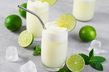 Brazilian Lemonade, Refreshing Creamy Lemonade or Limeade with Lime Slices and Mint on Grey Background