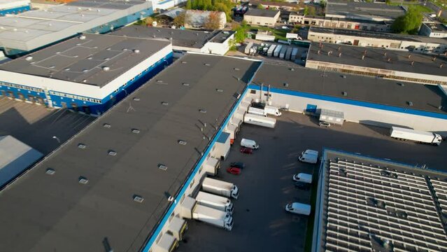 Areal footage of exterior of logistics center with trucks loaded 