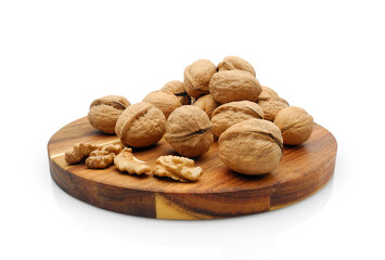 Walnuts on round wooden cutting board isolated on white background