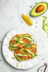 Open sandwiches with salted salmon, guacamole avocado and fresh greens. Delicious breakfast or snack, Clean eating, dieting, vegan food concept. top view.