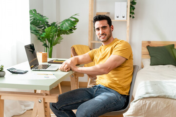 Optimistic man working with laptop from home.