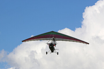 Fototapeta na wymiar Ultralight airplane flying in a cloudy sky