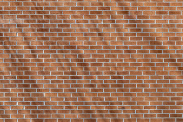 Close up texture background of a modern traditional exterior red clay brick wall in running bond (stretcher bond) pattern, with diagonal shadows cast from sunlight