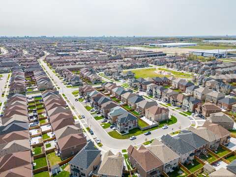 Drone view, sun-drenched Brampton real estate, lush green yards, picturesque houses off Bramalea-Mayfield. Summer in Ontario at its best."