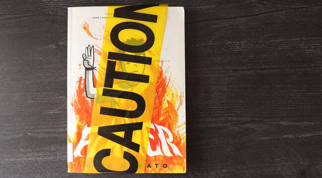 A copy of the book Flamer by Mike Curato, covered in caution tape. The book has landed on many school and library banned book lists.