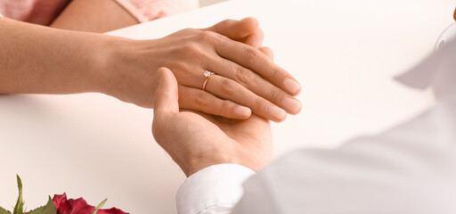 Engaged couple holding hands, closeup