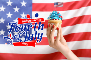 Female hand holding tasty patriotic cupcake against USA flag. Happy 4th of July