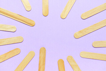 Frame made of ice cream sticks on purple background