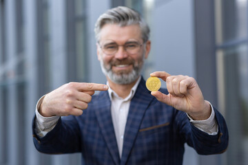 Bitcoin and cryptocurrency transactions. Portrait of a senior man in a suit standing near an office...