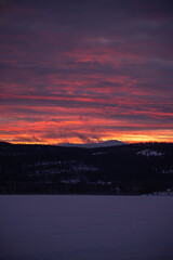 Fototapeta na wymiar Incredible bright pink, purple sunset views in winter season from northern Canada with bright pink clouds, mountains and snow at dusk.