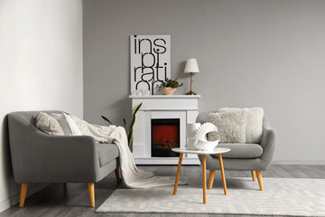 Interior of living room with cozy sofa, grey armchair and table