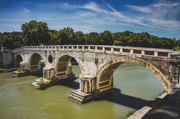 Malowniczy widok na mosty nad Tybrem i panoramę Rzymu. Te historyczne struktury tworzą unikalny krajobraz miasta, łącząc jego różne dzielnice i dodając uroku wiecznemu miastu.