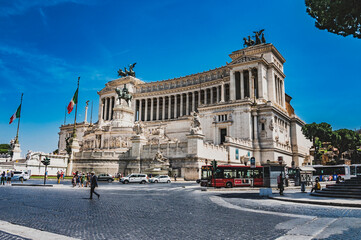 Fototapeta premium Plac Wenecki w Rzymie, jeden z najważniejszych placów w stolicy Włoch, pełen historycznych budynków i pomników. Jego szerokie przestrzenie i monumentalne struktury tworzą unikalną atmosferę.