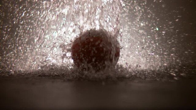 super slow motion of water drops falling on a tomato