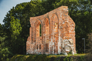 Dramatyczny widok fragmentu kościoła w Trzęsaczu, spadającego z klifu do morza. Ta zniszczona ruina jest świadectwem potężnej siły natury i nieuchronnego procesu erozji. 