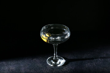 Glass of tasty martini on dark background