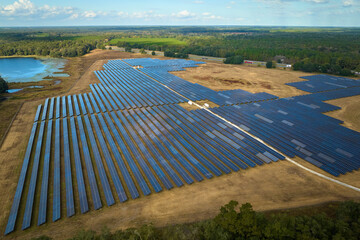 Aerial view of large sustainable electrical power plant with rows of solar photovoltaic panels for producing clean electric energy. Concept of renewable electricity with zero emission