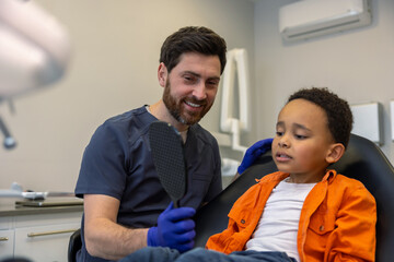 Obraz premium Male dentist working with dark-skinned boy