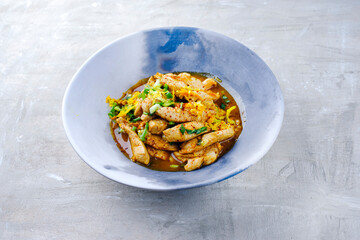 Traditional chicken fillet with orange and spring onion in aromatic vegetable broth served as close-up in a design plate with text space