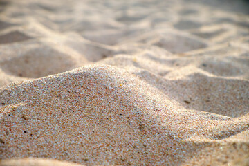 Close up of clean yellow sand surface covering seaside beach illuminated with day light. Travel and vacations concept