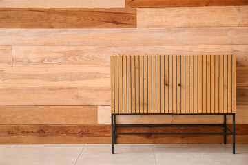 Chest of drawers near wooden wall in room