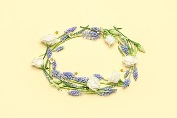 Frame made of different flowers on beige background