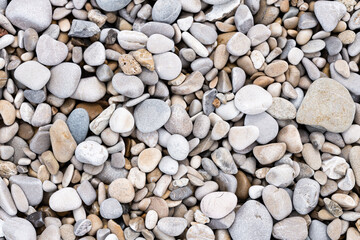 pebbles on beach. Stone wall background, sea coast