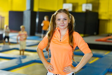 Smiling girl against the background of children playing in an amusement park