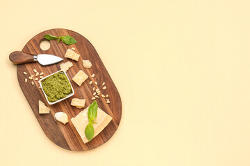 Bowl of delicious pesto sauce and ingredients on yellow background