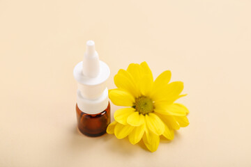 Nasal drops with daisy flower on beige background, closeup. Seasonal allergy concept