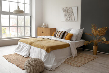 Interior of stylish bedroom with cozy bed and wooden cabinet near big window