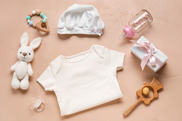 Composition with baby clothes, toys and accessories on beige background
