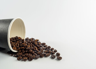 Roasted Arabica coffee beans, ready to make coffee that people like to drink. Placed in a black coffee cup paper on the background. Looks beautiful and appetizing. Drink.