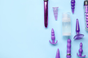 Bottle of lubricant and sex toys on blue background