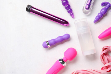 Bottle of lubricant and sex toys on white background