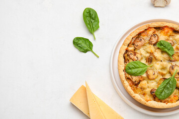 Mushroom pie with spinach leaves and cheese on white background
