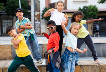 Group of children in casual clothes training hip-hop on street, learning modern dance movements - obrazy, fototapety, plakaty