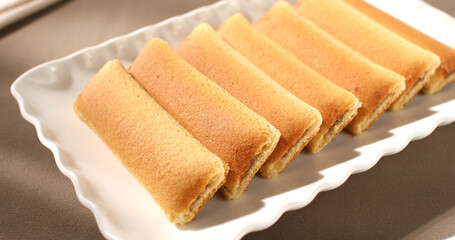 cookies on the table. strudel with fruit filling on a white plate. pastries on a brown background. sweet treat on a sunny day.