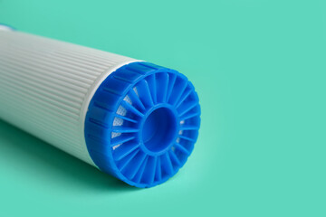 New water filter cartridge on green background, closeup