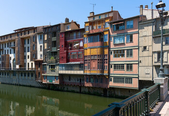 Charming houses line the river Agout in Castres, France, showcasing stunning architecture and beautiful reflections in the water. A picturesque and peaceful scene to admire.