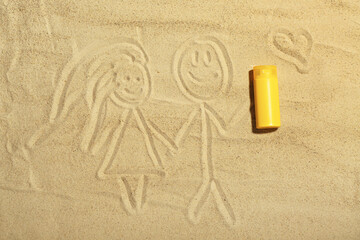 Creative composition with sunscreen cream and drawings on sand