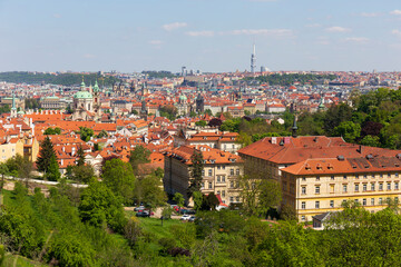 Fototapeta na wymiar Spring Prague City with St. Nicholas' Cathedral and colorful Nature with flowering Meadows from the Hill Petrin, Czech Republic