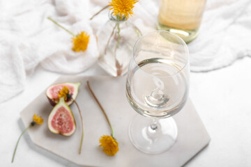 Fototapeta na wymiar Board with glass of dandelion wine on white background