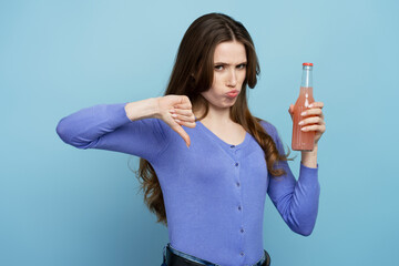 Portrait of unhappy sad woman in blue shirt making finger down