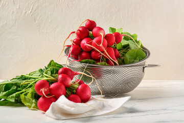 Colander with fresh radish on table