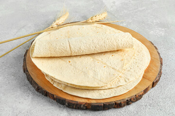 Wooden board with fresh lavash on grey background
