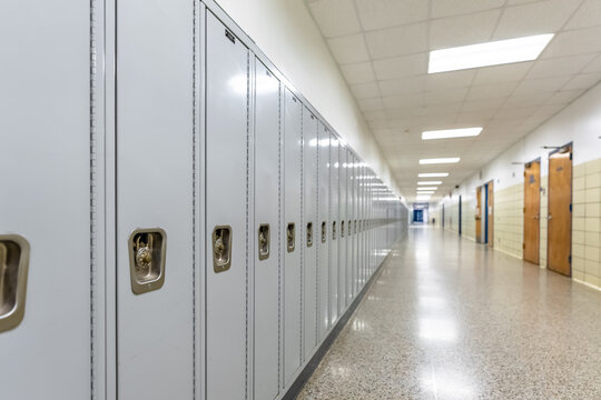 Empty middle school or high school hallway with gray student lockers
