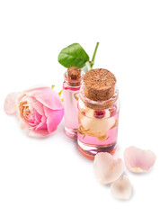 Bottles of cosmetic oil with rose extract and flower on white background