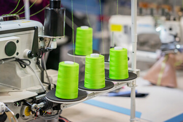 Spools with bright green threads on sewing machine closeup. Sewing Equipment, Fabric and Textile Industry